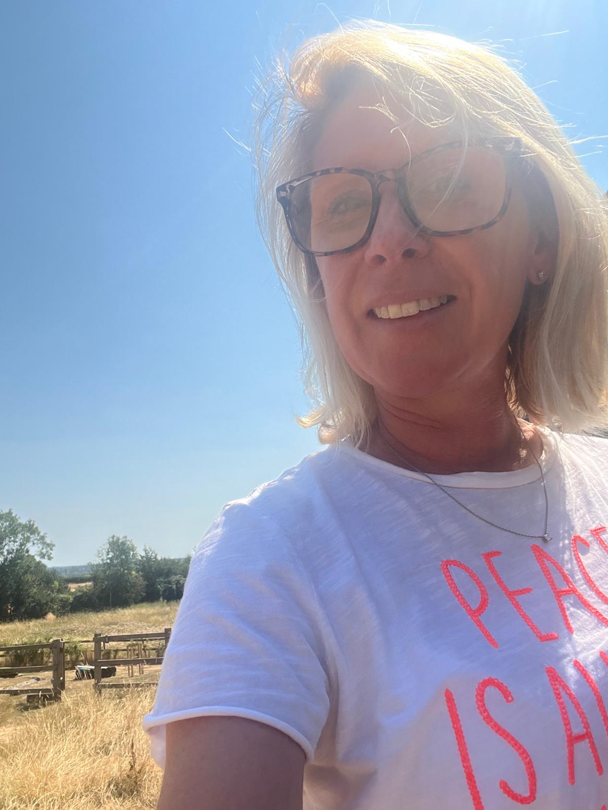 Nikki, founder of Down the Garden Path, smiling outdoors in a sunny Oxfordshire field